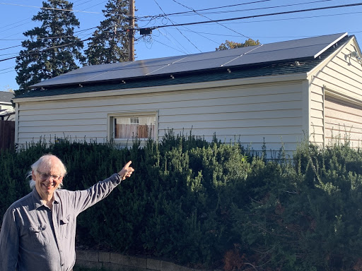 Rev. Lee Schaefer pointing to his garage, which was installed with an 8-panel solar array