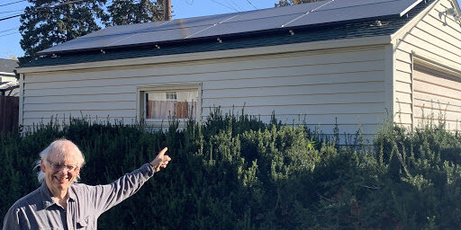 Rev. Lee Schaefer pointing to his garage, which was installed with an 8-panel solar array